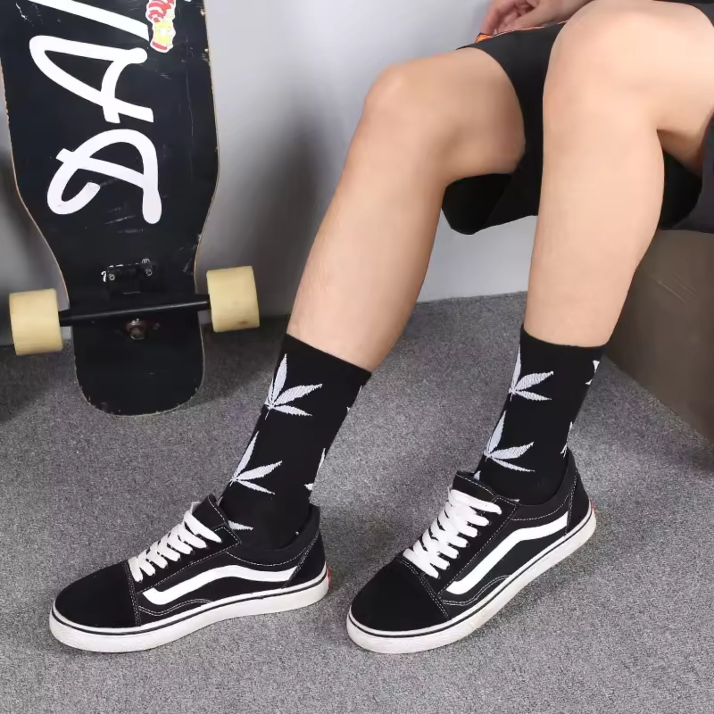 skateboader sittind down wearing black and white weed socks